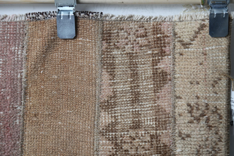 Close-up of handmade wool cotton runner rug showing faded brown weave with subtle pattern