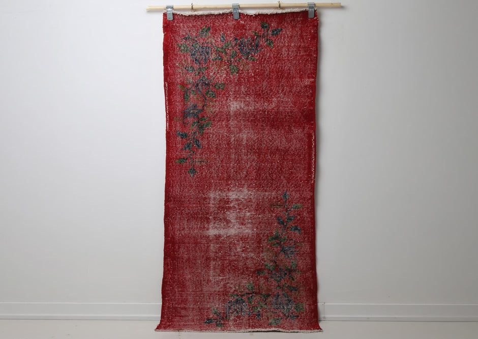 2'10 x 6'1 vintage Turkish runner rug hanging showing red field with small floral pattern