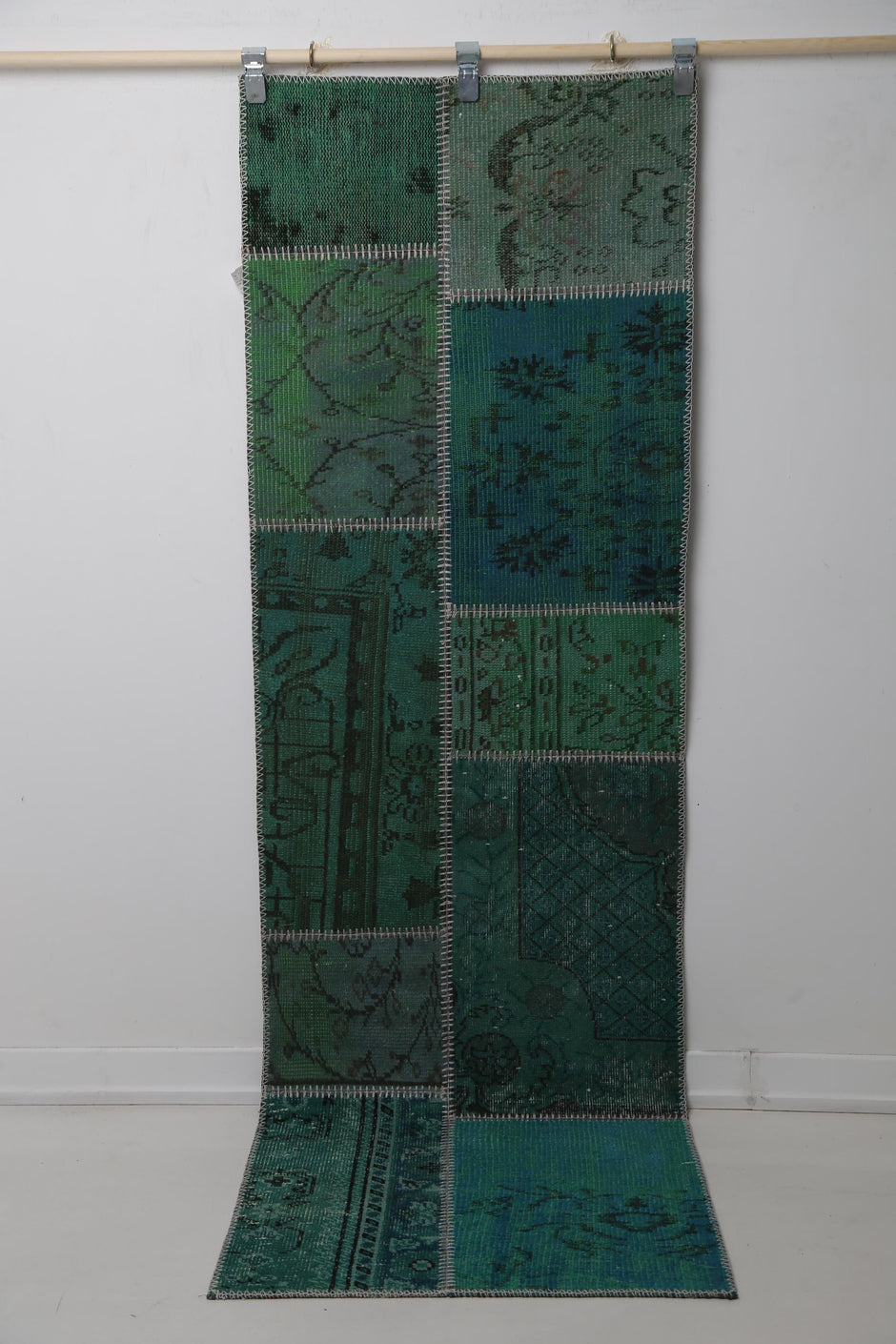 Close-up of vintage Turkish runner rug panel showing faded floral motif on deep green field