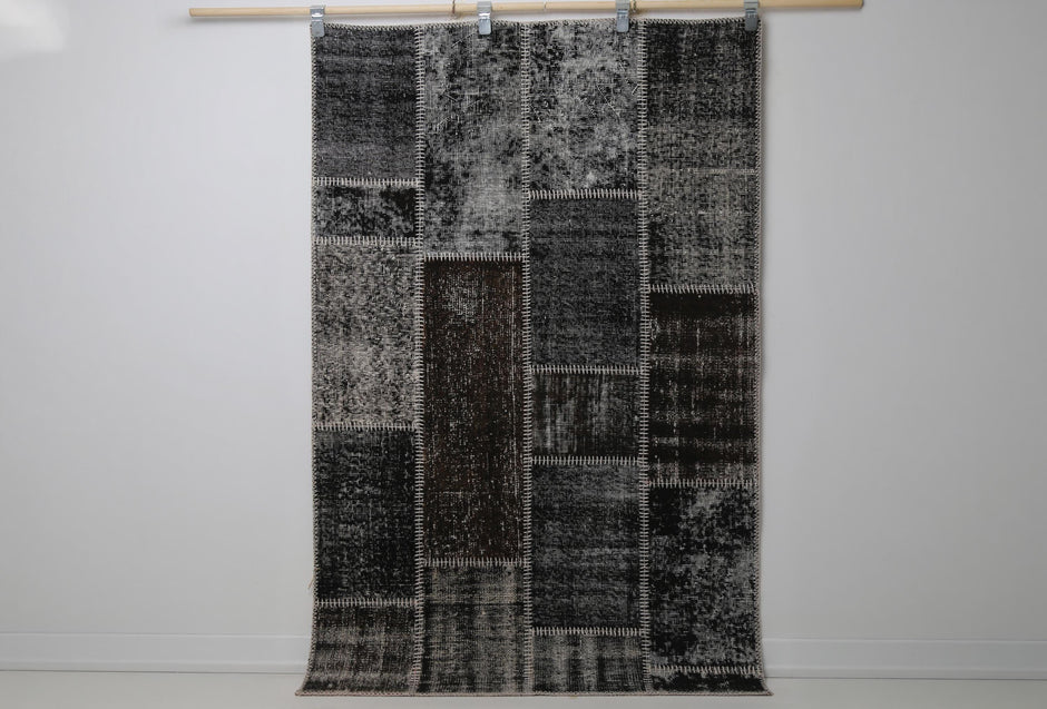 3'11 x 6'1 vintage Turkish patchwork rug hanging showing black brown distressed panel design