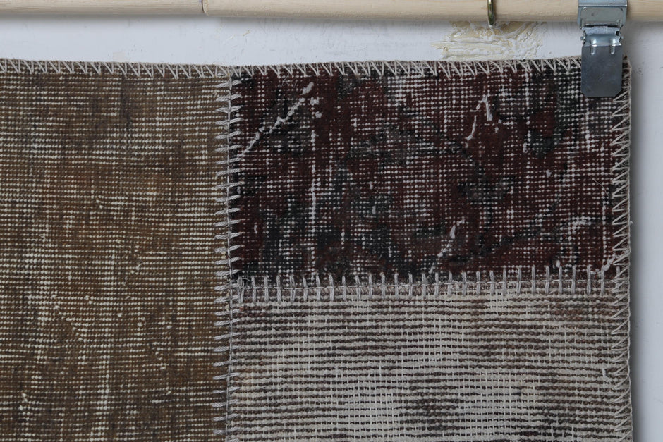 Close-up of handmade wool cotton runner rug showing faded burgundy and gray distressed panel texture
