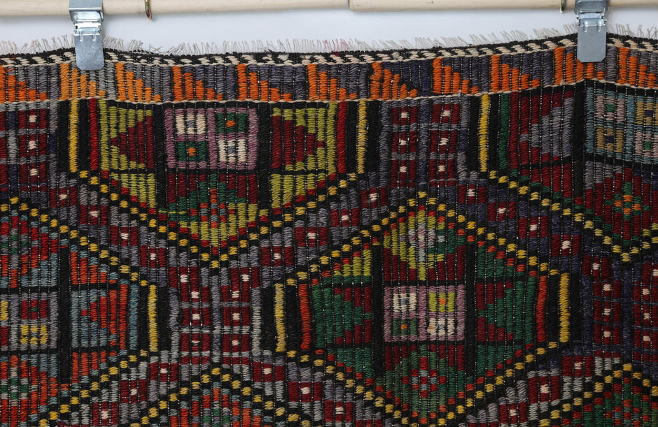 Vintage oriental flatweave rug detail showing multicolor diamond and geometric tribal design