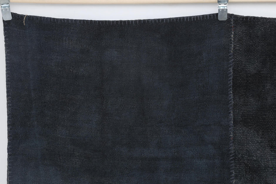 Close-up of stitched patchwork construction on dark blue hemp rug
