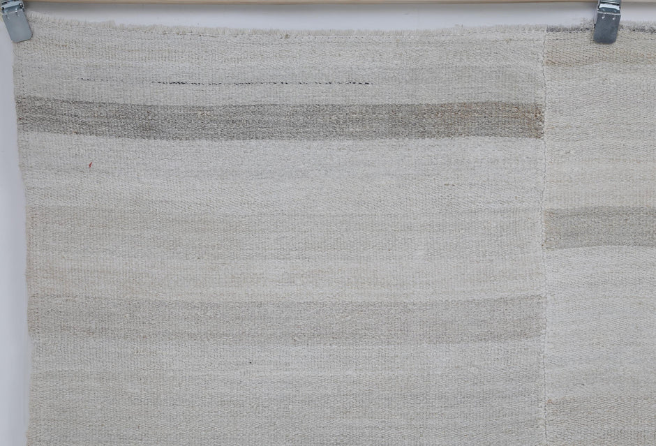 Close-up of striped detail on white beige hemp flatweave rug