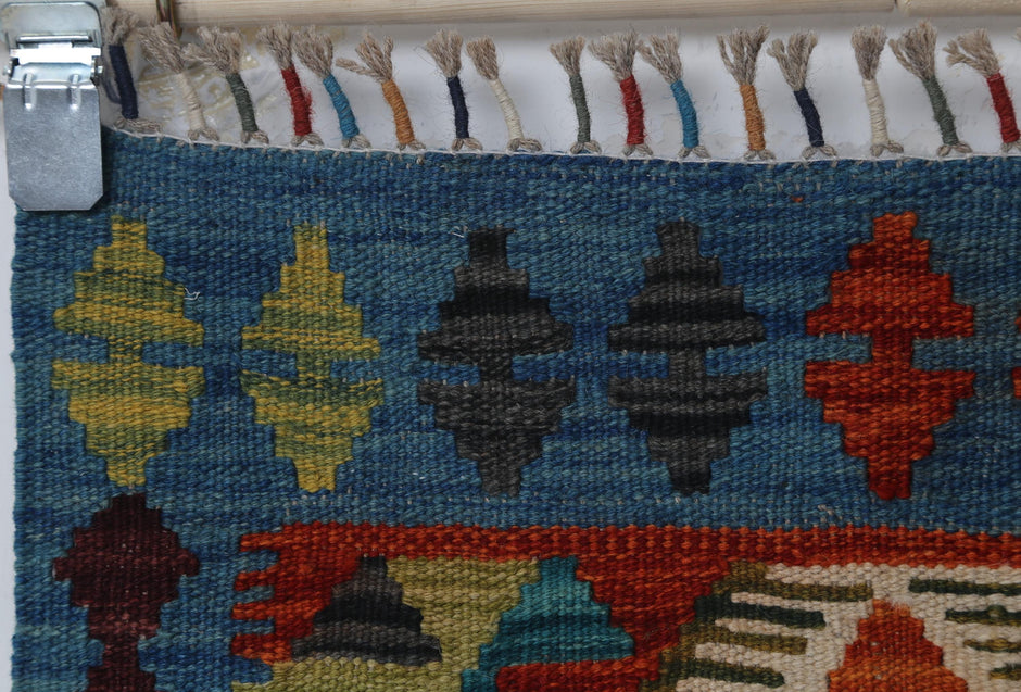 Vintage blue kilim rug displayed in entryway or bedside setting