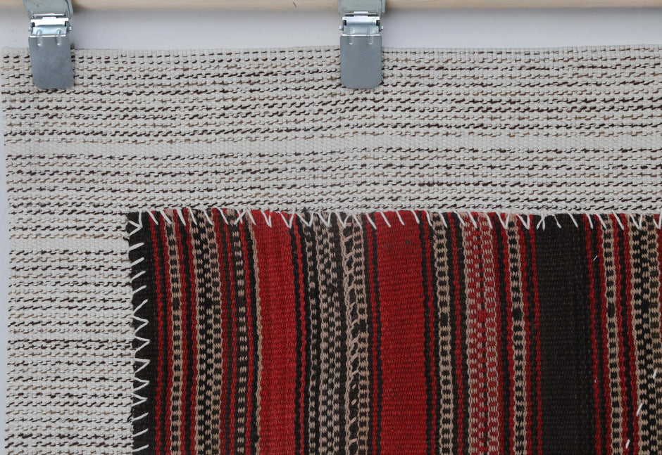 Red striped tapestry displayed as wall decor in bohemian interior