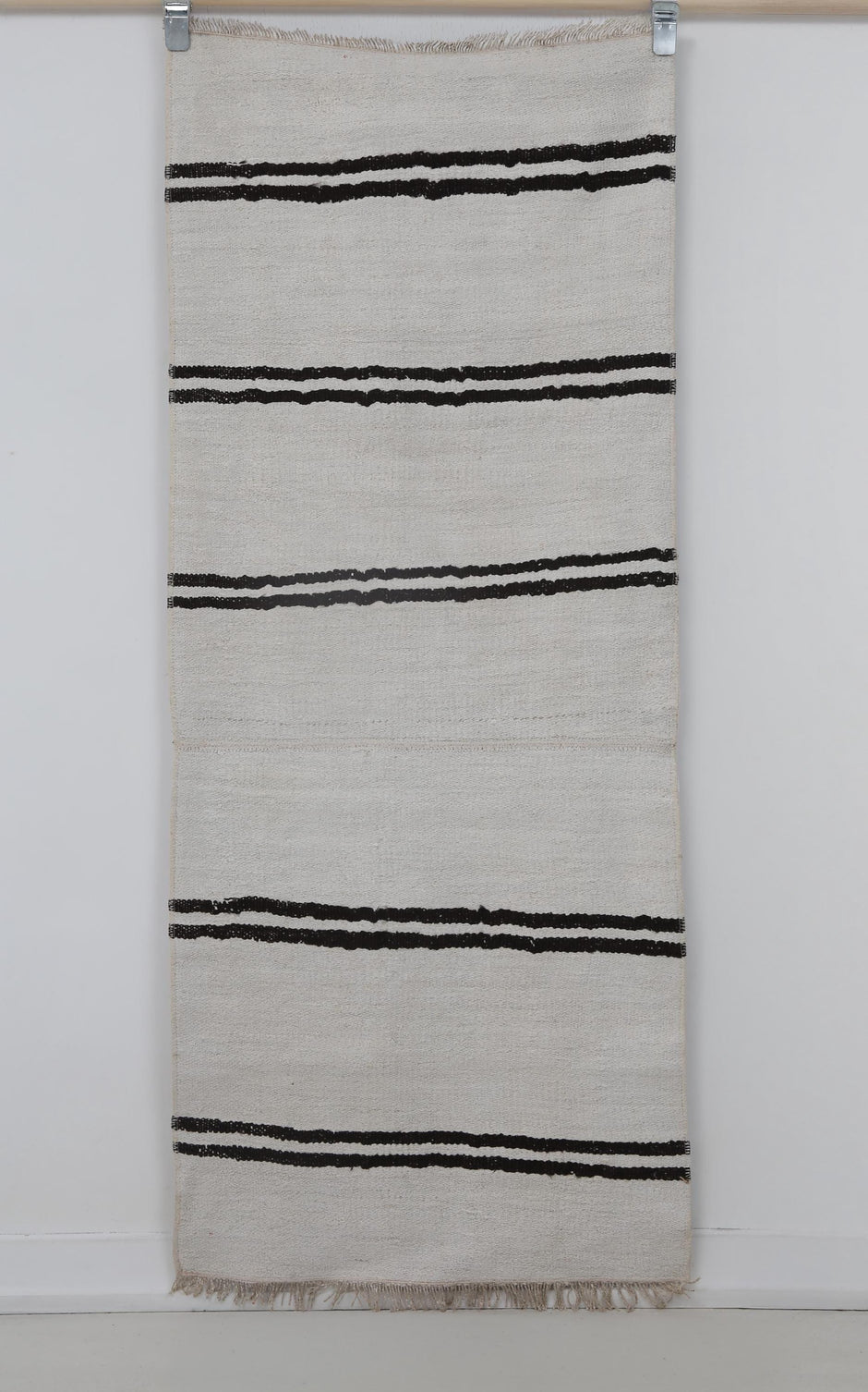 Close-up of black striped detail on white hemp runner rug