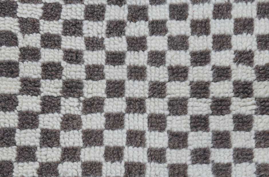 A close-up of a black and white checkerboard patterned plush rug or carpet texture.