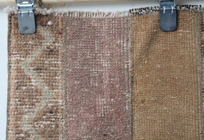 Full vintage patchwork runner rug hanging showing long brown tan hallway carpet design
