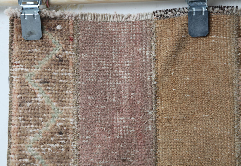 Full vintage patchwork runner rug hanging showing long brown tan hallway carpet design