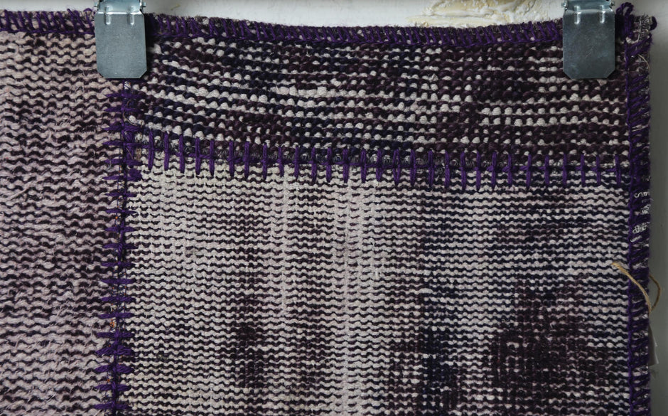 Full vintage patchwork runner rug hanging showing purple panels with faded gray section