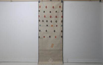 2'3 x 6'1 vintage Turkish kilim runner rug hanging showing beige field with scattered tribal diamond motifs