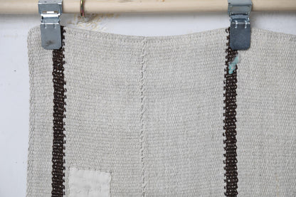Full vintage hemp runner rug hanging showing minimal white and black long striped hallway rug