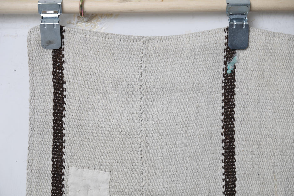 Full vintage hemp runner rug hanging showing minimal white and black long striped hallway rug
