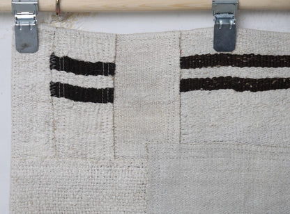 Full vintage hemp patchwork runner rug hanging showing long minimal black white patterned hallway rug