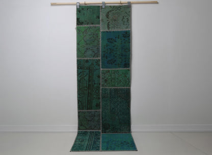 2'5 x 7'8 vintage Turkish patchwork runner rug hanging showing rich emerald green overdyed pattern