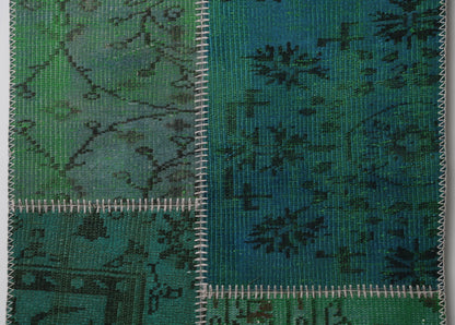 Close-up of handmade wool runner rug showing dark teal green distressed weave texture