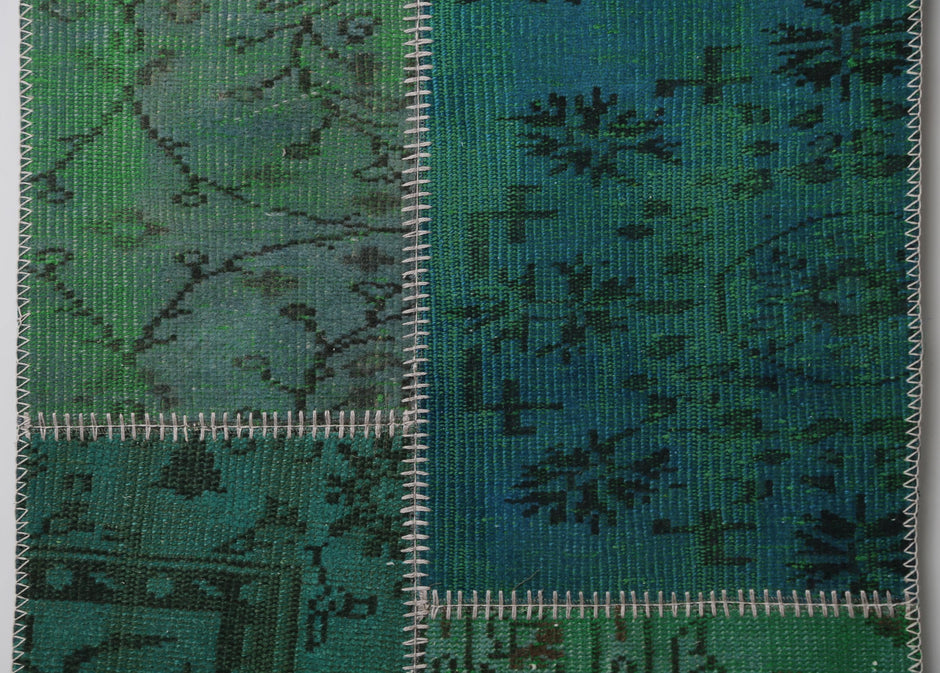 Close-up of handmade wool runner rug showing dark teal green distressed weave texture