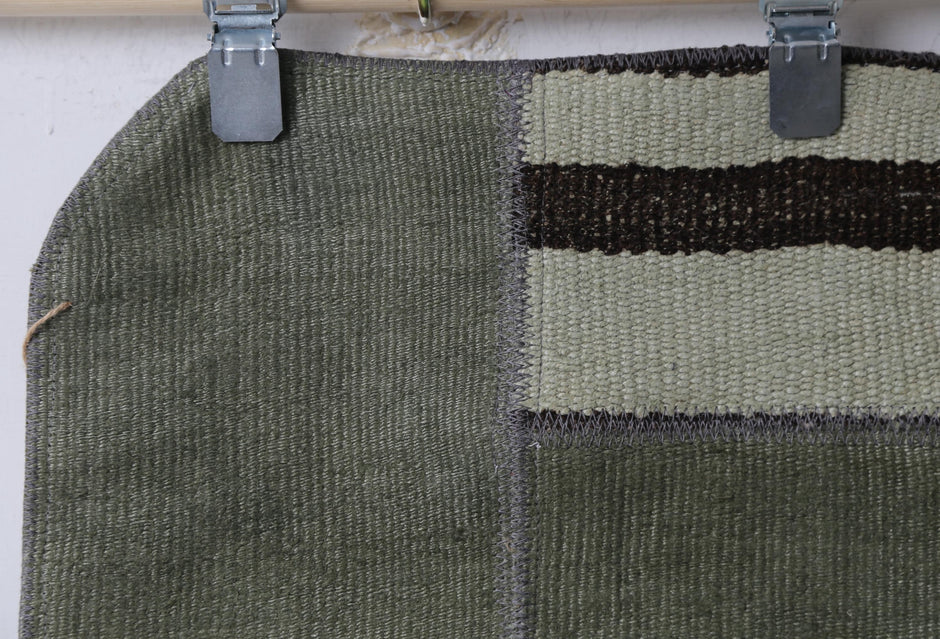 Green patchwork doormat close-up, panel seams hemp texture
