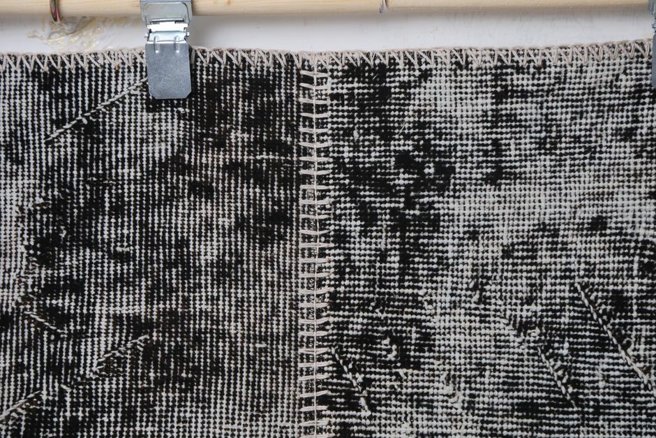Detail shot of vintage Turkish patchwork rug panel showing charcoal and brown speckled texture