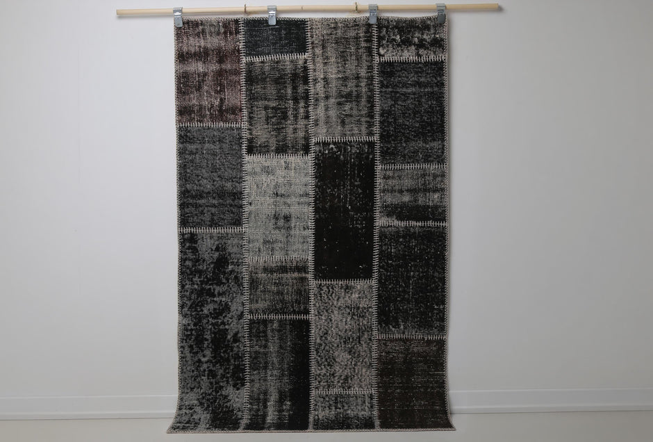 3'11 x 6'2 vintage Turkish patchwork rug hanging showing dark black brown mottled panel design