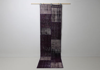 2'3 x 8'4 vintage Turkish patchwork runner rug hanging showing rich purple overdyed panel design