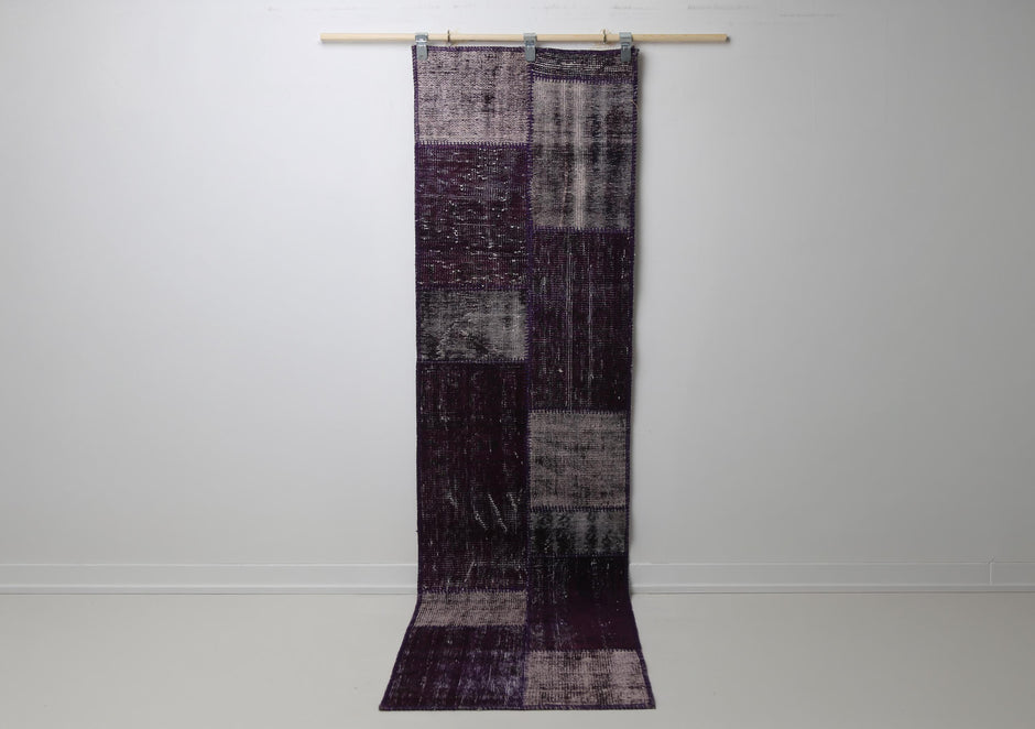 2'3 x 8'4 vintage Turkish patchwork runner rug hanging showing rich purple overdyed panel design