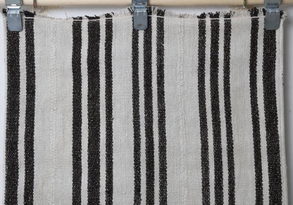 Full vintage hemp runner rug hanging showing long white and black vertically striped hallway rug