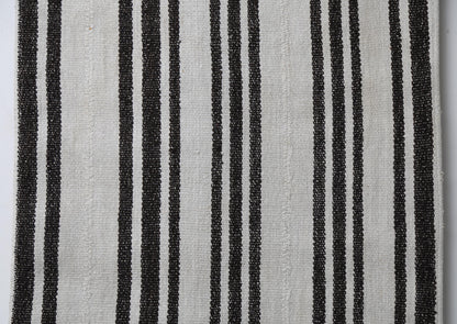 Close-up of handmade natural fiber runner rug showing pinstripe black lines on cream weave