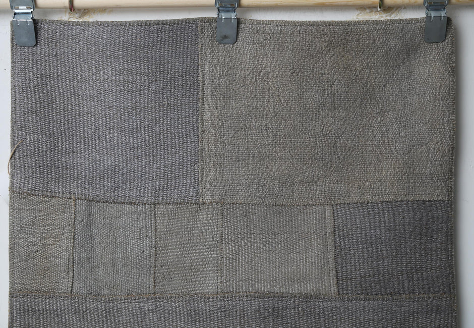 Close-up of handmade natural fiber runner rug showing dark gray ribbed panel weave texture