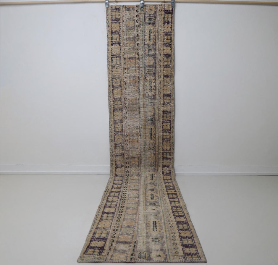 1'11 x 10'9 vintage Turkish runner rug hanging showing long beige brown patchwork design