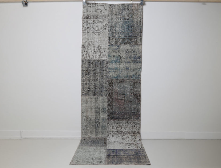 2x8 vintage Turkish patchwork runner rug hanging showing overdyed gray blue faded pattern