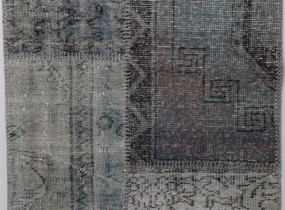 Close-up of handmade wool cotton runner rug showing faded gray blue vintage pattern texture