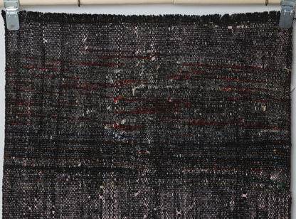Detail shot of vintage Turkish runner rug texture showing dark distressed striped weave