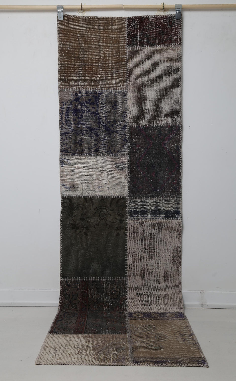 Close-up of vintage Turkish runner rug texture showing distressed brown and cream panel weave