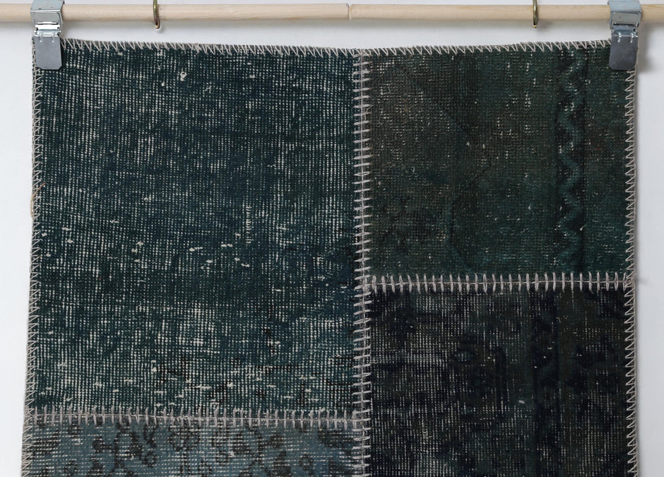 Detail shot of vintage Turkish patchwork rug panel showing rich green overdyed texture
