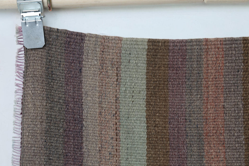 Full vintage Turkish kilim runner hanging showing narrow striped hallway rug design