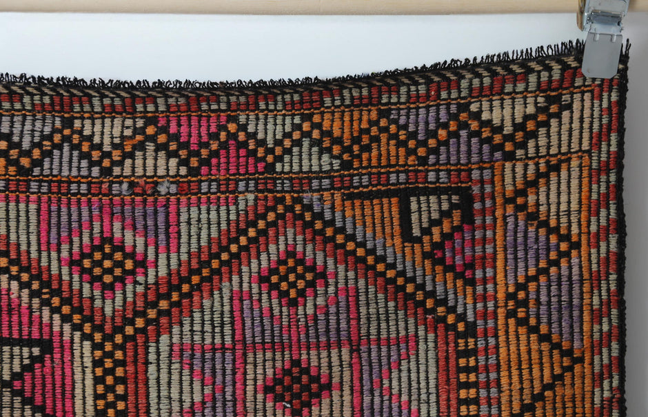 Vintage oriental flatweave rug detail showing large geometric octagon pattern in red and black
