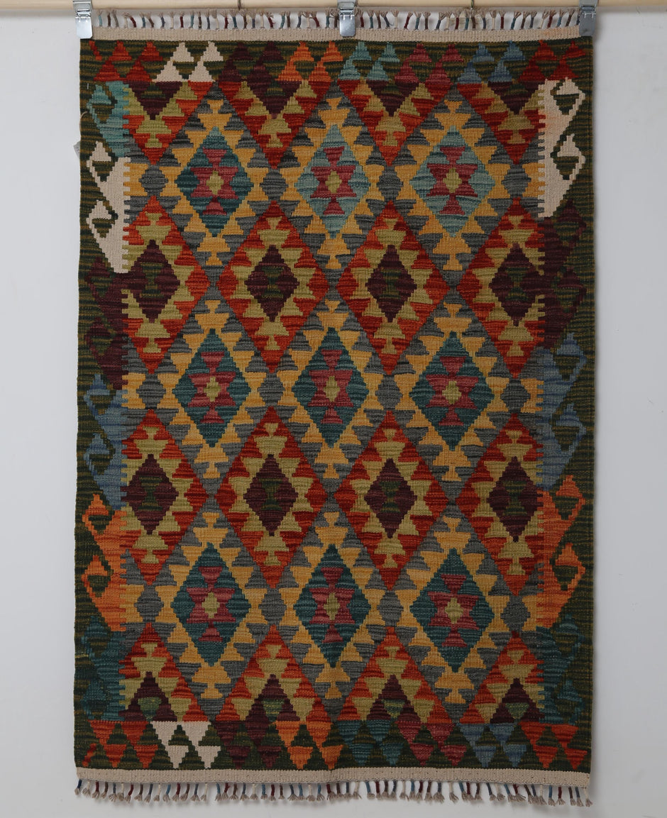 Close-up of vintage Turkish flatweave rug showing red, teal, gold and orange triangle rows