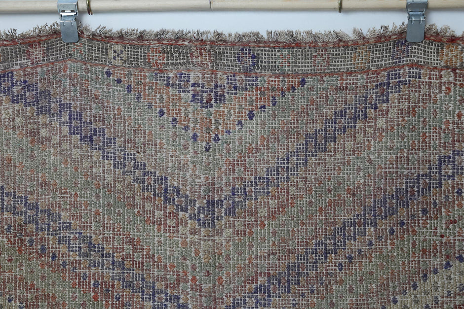 Vintage oriental flatweave rug detail showing muted multicolor zigzag chevron design