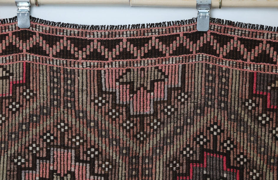 Vintage oriental flatweave rug detail showing brown, pink and cream geometric border pattern