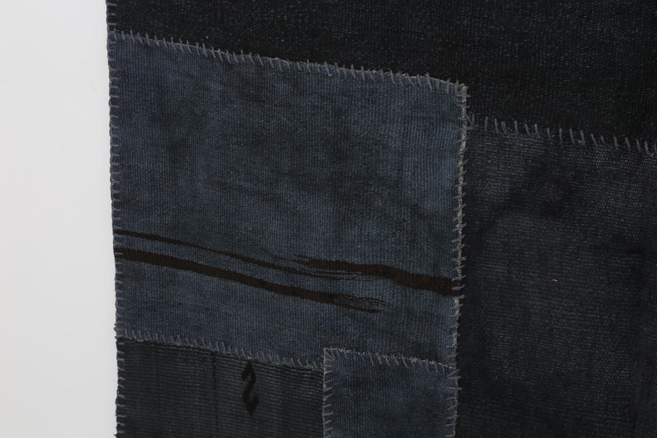 Full vintage hemp patchwork rug hanging with color palette swatches in shades of blue