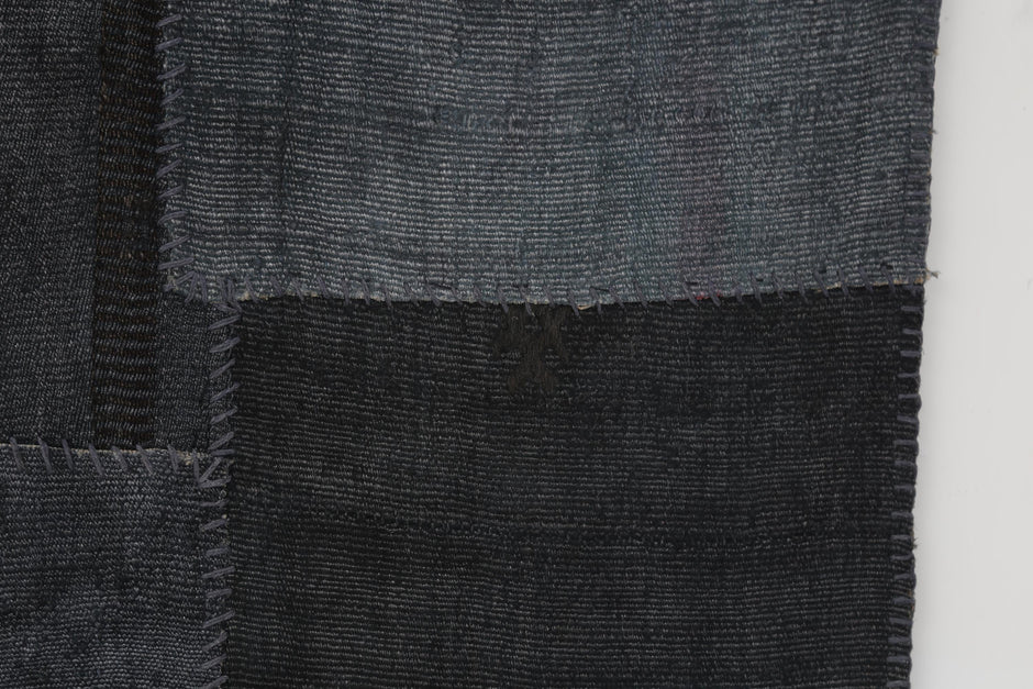 Vintage hemp patchwork rug detail showing navy blue woven panel texture