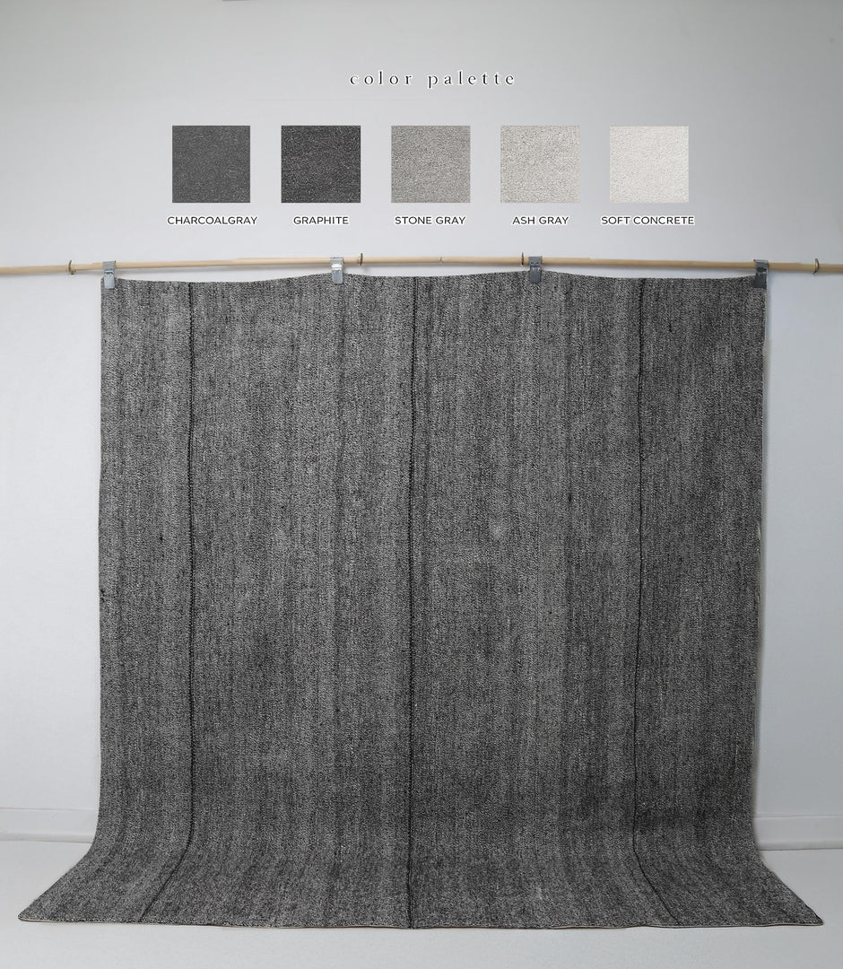 Close-up of vintage Turkish kilim rug texture showing black and grey woven stripes