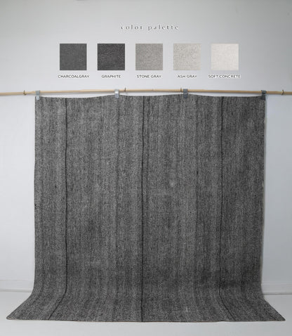 Close-up of vintage Turkish kilim rug texture showing black and grey woven stripes
