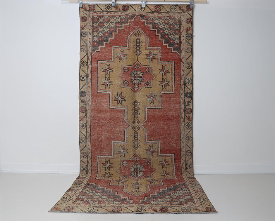  Close-up of geometric medallion detail on red yellow runner rug