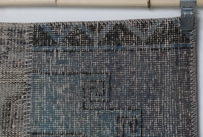 Close-up of handmade wool cotton runner rug showing faded blue vintage weave with tan patch