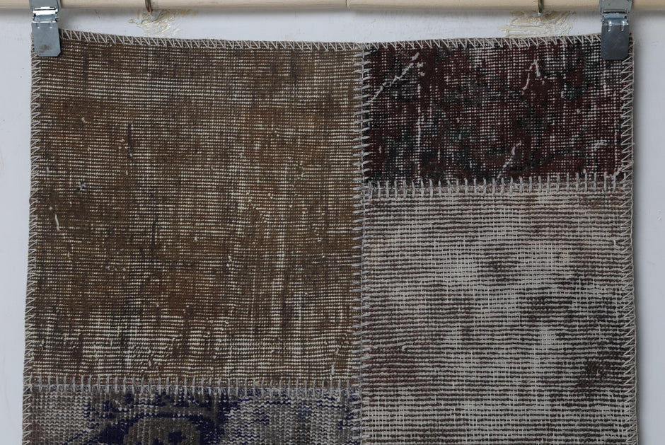 Detail shot of vintage Turkish patchwork rug panel showing brown and cream distressed weave block