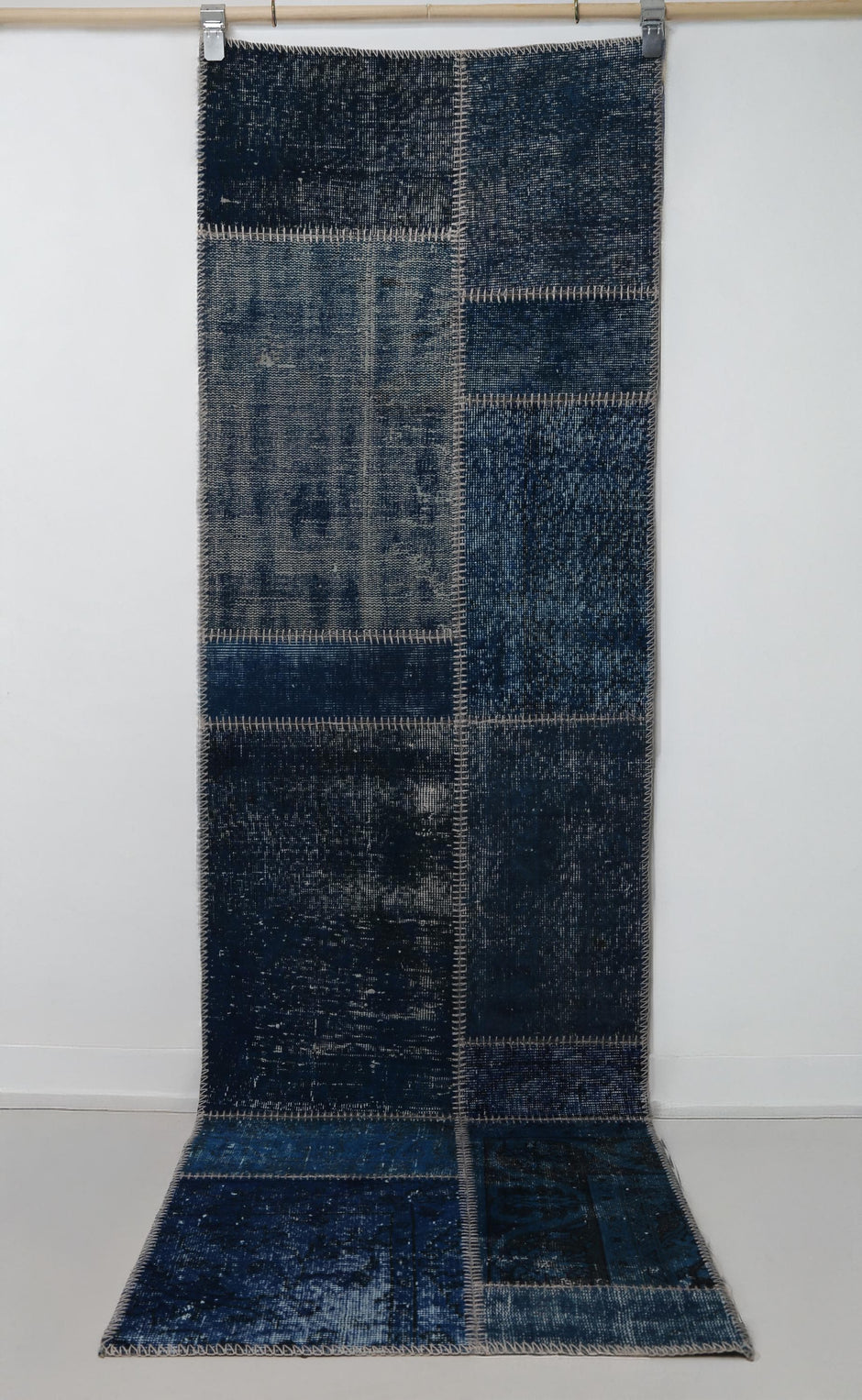 Close-up of vintage Turkish runner rug texture showing deep blue distressed woven panels