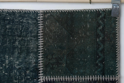 Close-up of handmade wool cotton runner rug showing deep teal green distressed weave with zigzag seam